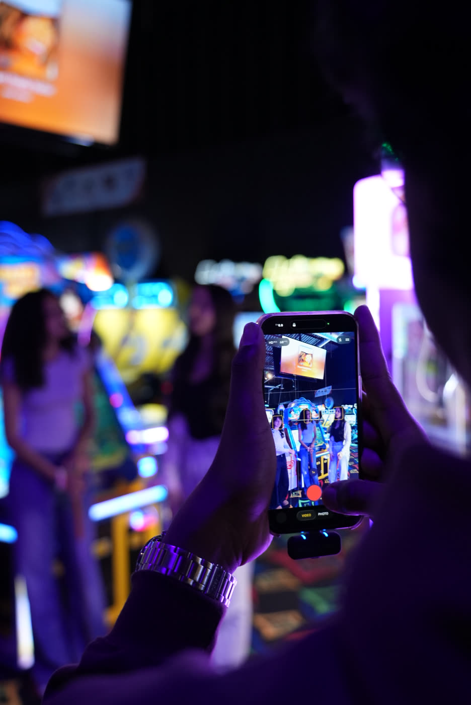 Filming a vertical shot on a phone at an arcade shoot.